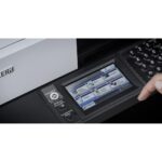 Stampante Kyocera ECOSYS Multifunzione, in primo piano il display touch con una mano